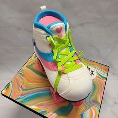 a pair of colorful sneakers sitting on top of a glass plate with marbled surface