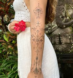 a woman with a tattoo on her arm holding a flower