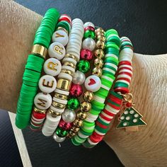 a woman's arm with bracelets on it and christmas decorations in different colors