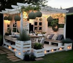 an outdoor seating area is lit up with candles