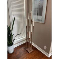 a tall metal candle holder sitting next to a window