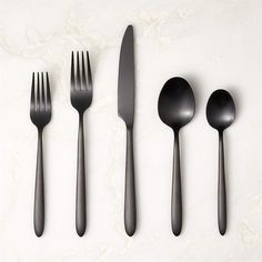 four forks, two spoons and one knife on a white surface