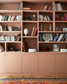 a bookshelf filled with lots of books on top of a hard wood floor