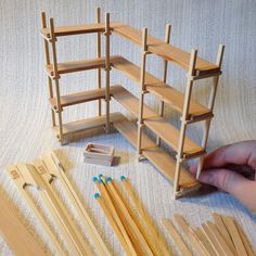 a person is making wooden shelves out of sticks and dows with their hands on the floor