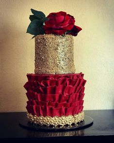 a three tiered cake with red and gold ruffles