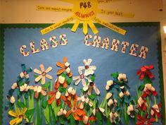 a bulletin board with paper flowers on it and the words class charter written in large letters