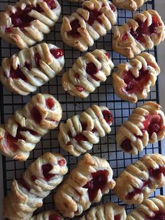 many pastries are on a cooling rack and ready to be baked in the oven