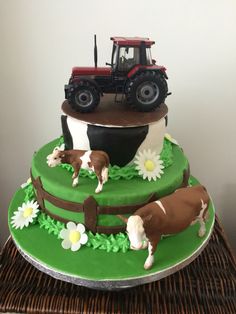 there is a tractor and farm animals on the cake