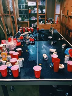 the table is covered with plastic cups and cans