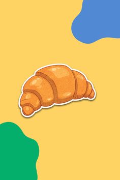 an orange croissant sticker sitting on top of a yellow and green background