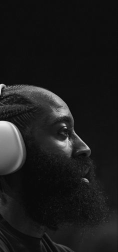 a black and white photo of a man with a beard wearing headphones on his ears