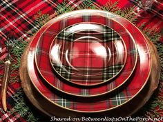 a red and black plaid table setting with silverware on the plate, napkins and utensils