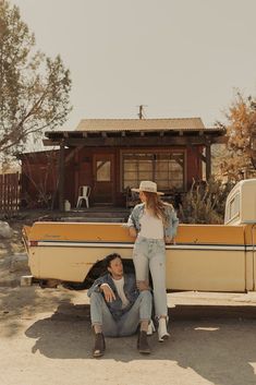 a man and woman sitting on the back of a boat in front of a cabin