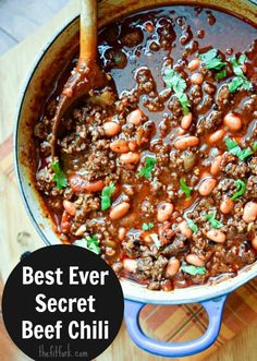 a pot filled with chili and beans on top of a wooden table