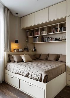 a bed sitting under a window next to a book shelf