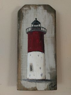 a painting of a red and white lighthouse on a wooden plaque hanging on a wall