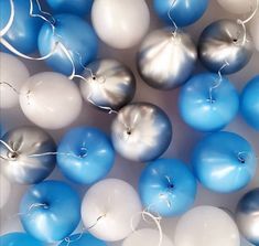 some blue and white balloons are in the air