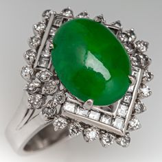 This lovely vintage ring is centered with one (1) oval cabochon cut natural jadeite jade set into a four-prong setting. The jade is bordered with eighteen (18), channel set, baguette cut diamonds and thirty (30), prong set, round brilliant cut diamonds. The ring measures 19.0mm at the top, rises 9.7mm above the finger, tapering to 2.8mm wide and 1.1mm thick at the base of the shank. This ring is currently a size 4.5. Formal Oval Jade Emerald Ring, Art Deco Jade Jewelry For Formal Occasions, Formal Art Deco Jade Jewelry, Elegant Emerald Jade Ring With Cabochon, Formal Art Deco Oval Emerald Ring, Classic Jade Rings For Formal Occasions, Luxury Jade Ring For Formal Occasions, Elegant Jade Cabochon Rings, Elegant Jade Rings With Cabochon