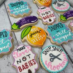 decorated sugar cookies with sayings on them sitting on a wooden table next to scissors