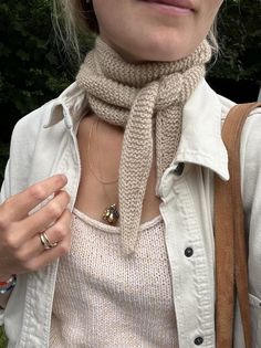 a woman wearing a beige scarf around her neck