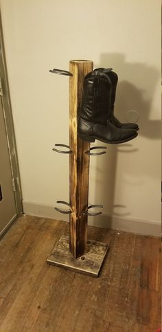 a pair of black boots are sitting on a wooden stand