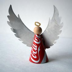 an ornament with wings and a coca - cola bottle in the shape of an angel