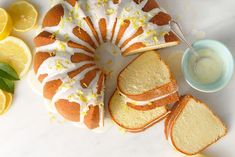 a lemon bunt cake with white icing and sliced lemons next to it