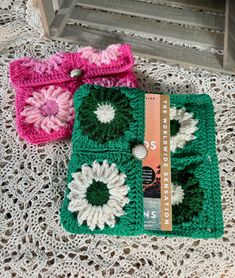 two crocheted bags sitting on top of a doily next to each other