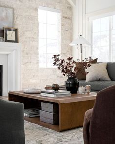 a living room filled with furniture and a fire place in front of a brick wall