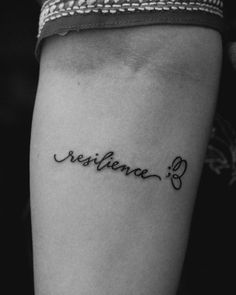 a woman's arm with the word resistance tattooed on her left side ribcage