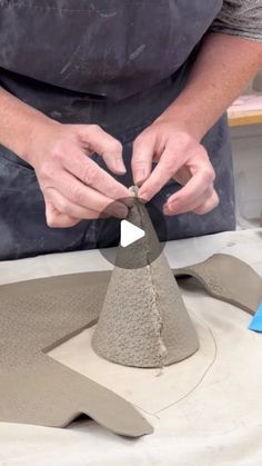 a man is making a sand sculpture with his hands