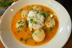 a white plate topped with soup and dumplings