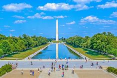 people are walking around in front of the washington monument and reflecting pool with water on it