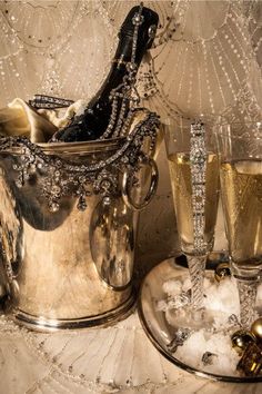 two champagne glasses and an ice bucket on a table