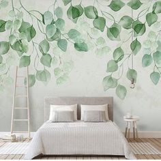 a bed sitting under a green leafy wall mural