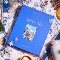 a blue book sitting on top of snow covered ground next to other items and utensils