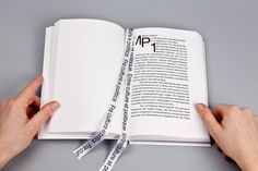 two hands holding an open book with tape around it