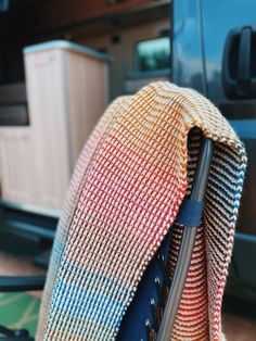 a multicolored knitted bag with an umbrella sticking out of it's side