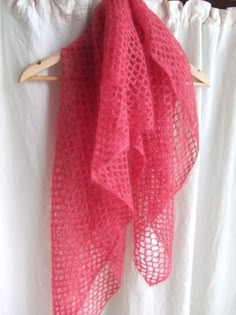 a pink scarf hanging on a wooden hanger