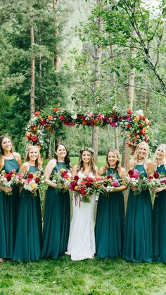 a group of bridesmaids in green dresses holding bouquets