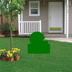 a red lawn sign sitting on top of a lush green field next to a tree