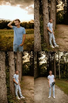 a man standing next to a tree on top of a dirt road in front of trees