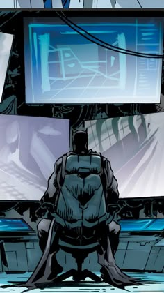 a man sitting on top of a chair in front of a tv screen with the batman standing next to him