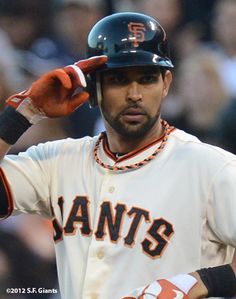 a baseball player is holding his helmet on