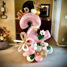 a pink balloon tower with balloons and decorations