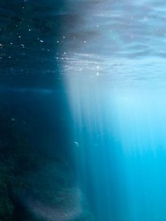 an underwater view of the ocean with blue water