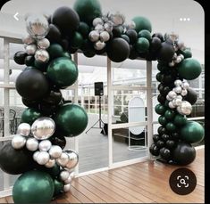 the balloon arch is decorated with black, white and green balloons