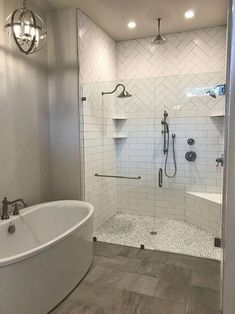 a large white bath tub sitting next to a walk in shower with two lights on the ceiling