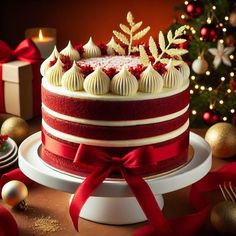 a red velvet cake with white frosting and christmas decorations on the table next to it