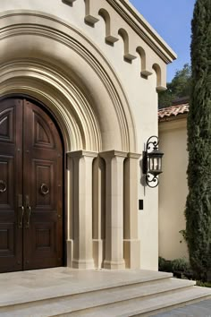 an entrance to a house with two doors and steps leading up to the front door